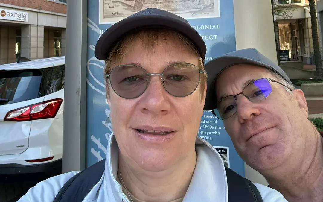 Two people in front of a historical sign on Boston Greenway during a self-guided city exploration game.