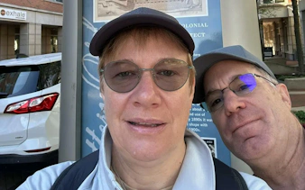 Two people in front of a historical sign on Boston Greenway during a self-guided city exploration game.