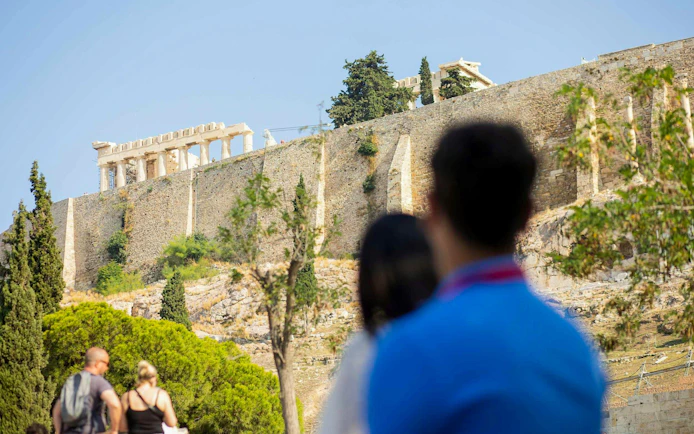 Tourists viewing the Parthenon on the Acropolis in Athens.