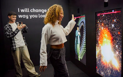 Guests interacting with digital displays at the Twist Museum in London.