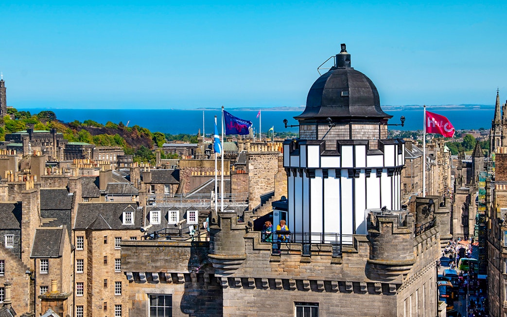 Camera Obscura & World of Illusions tower with Edinburgh skyline and sea in the background.
