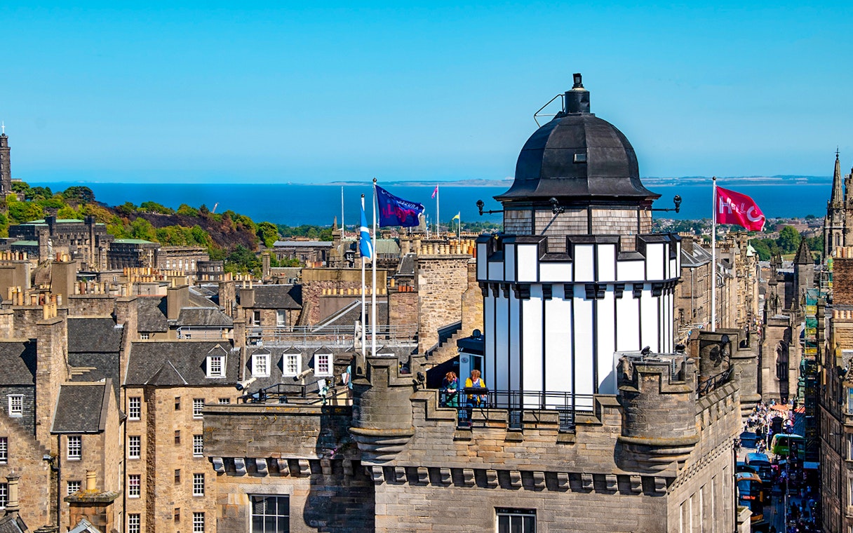 Camera Obscura & World of Illusions tower with Edinburgh skyline and sea in the background.