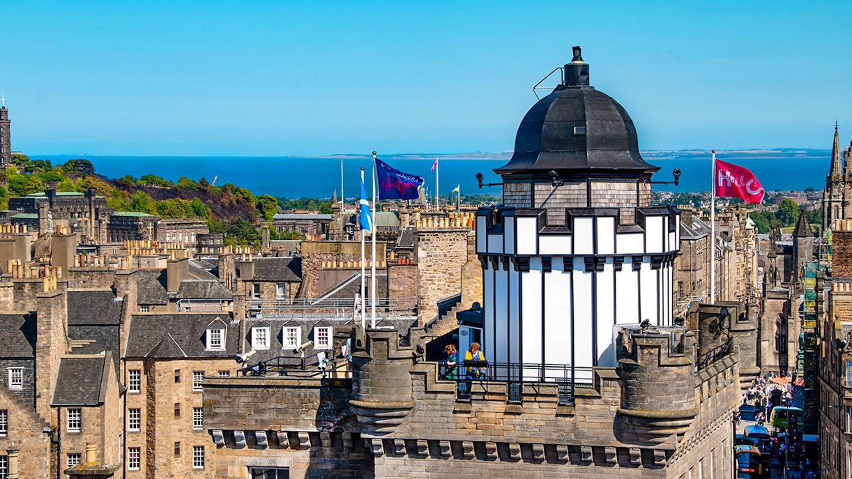 Camera Obscura & World of Illusions tower with Edinburgh skyline and sea in the background.