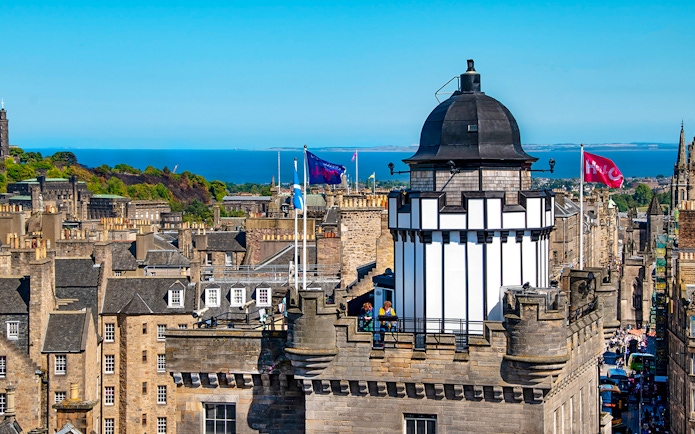 Camera Obscura & World of Illusions tower with Edinburgh skyline and sea in the background.