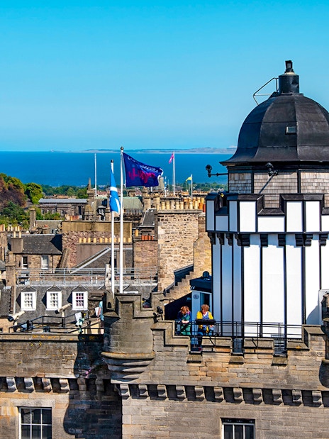 Camera Obscura & World of Illusions tower with Edinburgh skyline and sea in the background.
