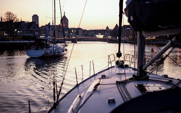 Sailboats on Gdansk River at sunset during a cruise with Prosecco.
