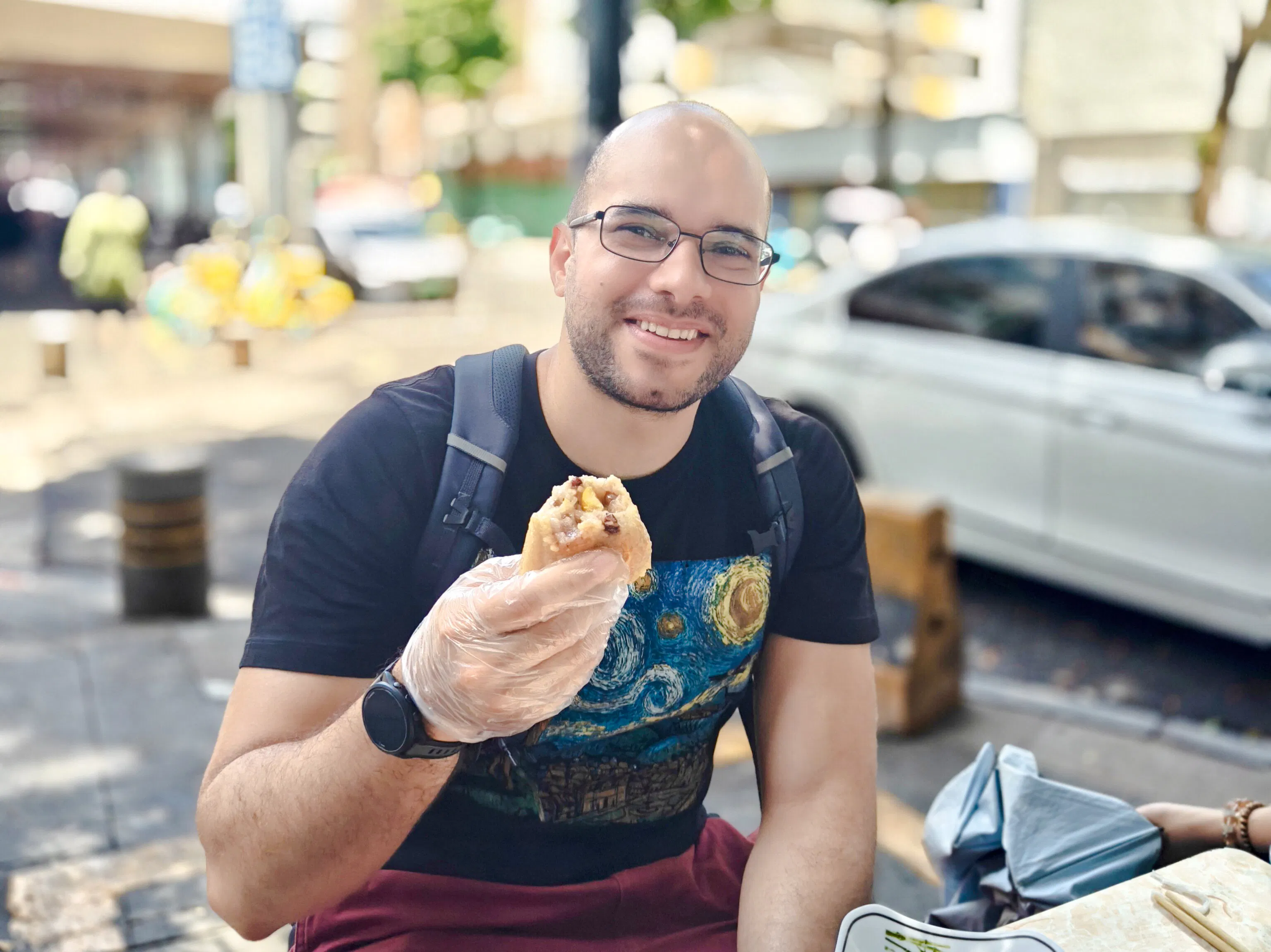 Man enjoying local street food in Shenzhen neighborhood.