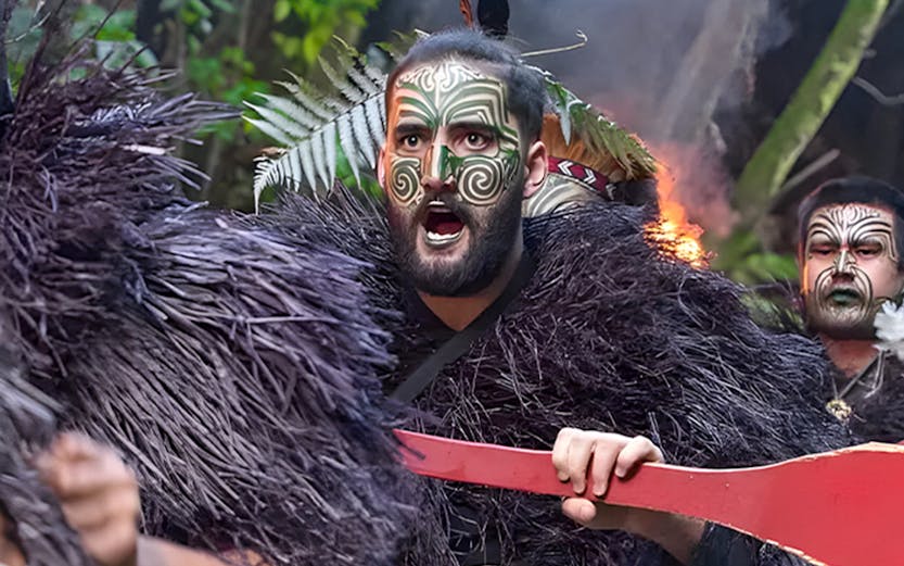Warriors paddling a canoe at Mitai Maori Village, New Zealand.