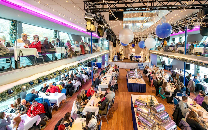 Afternoon advent cruise in Cologne with guests dining and festive decorations.