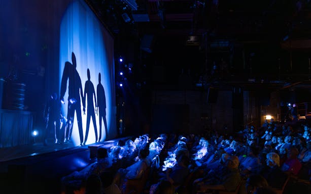 Blue Man Group performing on stage with audience in Orlando theater.