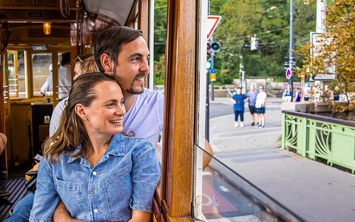 Couple enjoying view from historical tram in Prague.