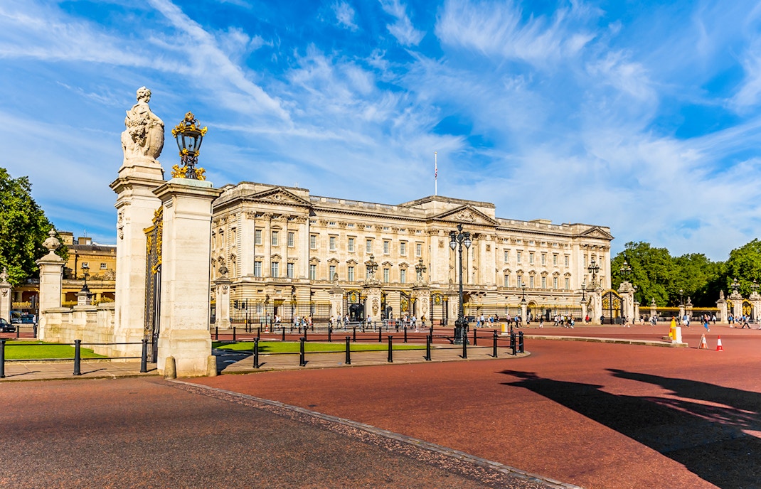 Buckingham Palace East Front with tourists gathered in London, England.