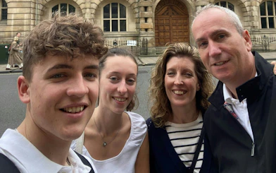 Group enjoying Oxford Time Thief self-guided city exploration game in front of historic building.