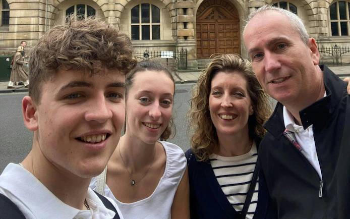 Group enjoying Oxford Time Thief self-guided city exploration game in front of historic building.