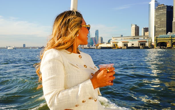 Guest enjoying a drink on a Statue of Liberty and NYC landmarks sightseeing cruise.