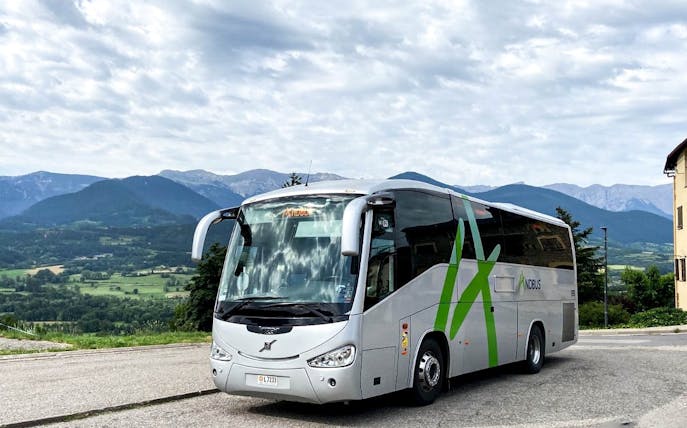 Bus traveling through scenic mountains near Andorra la Vella.