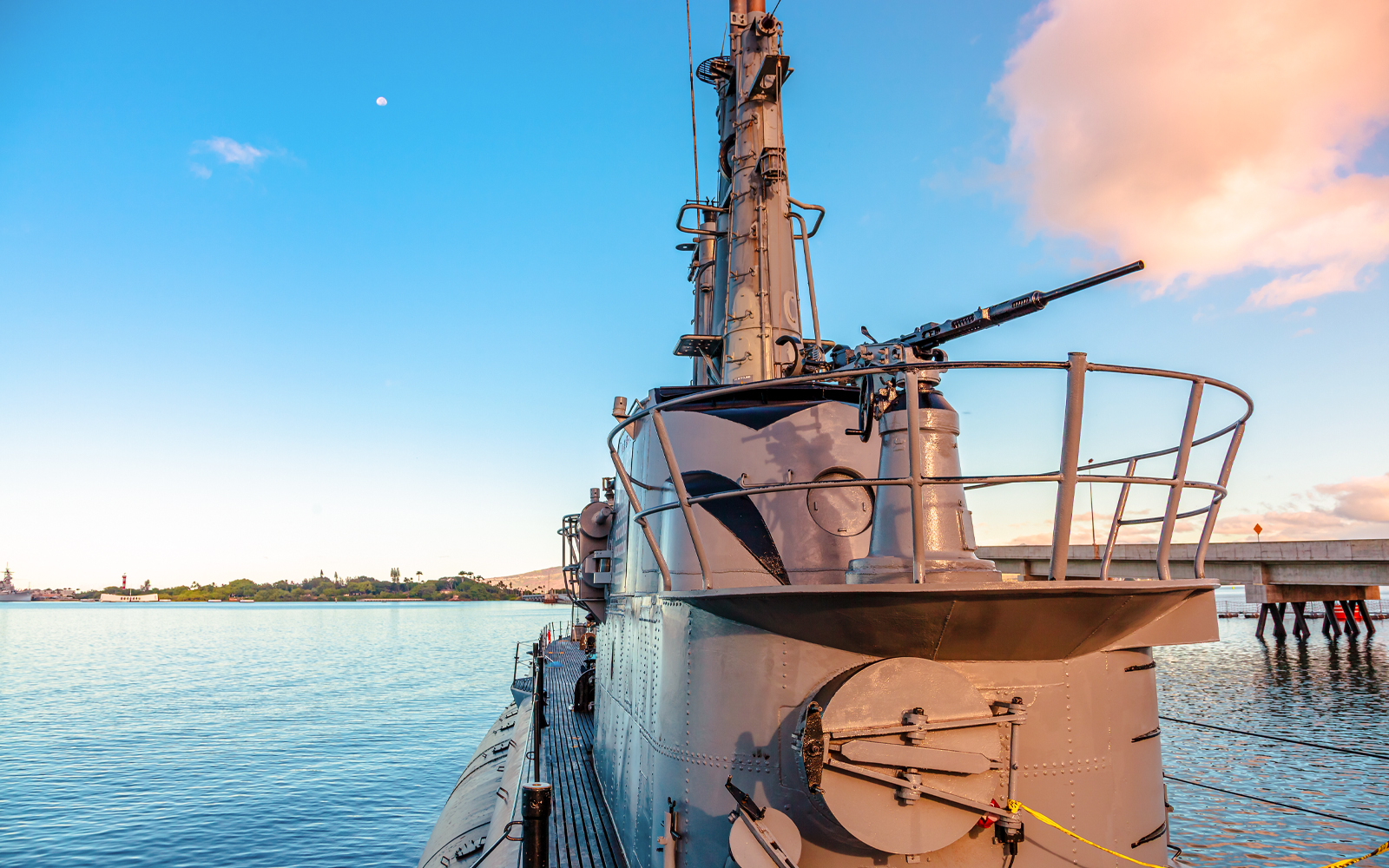 USS Bowfin Submarine docked at Pearl Harbor with clear sky and water.