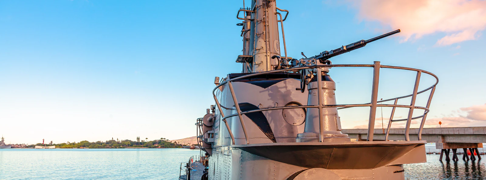 USS Bowfin Submarine docked at Pearl Harbor with clear sky and water.