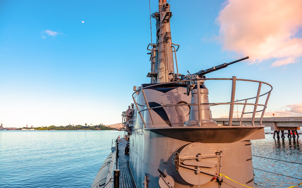 USS Bowfin Submarine docked at Pearl Harbor with clear sky and water.