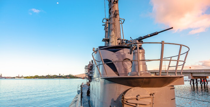 USS Bowfin Submarine docked at Pearl Harbor with clear sky and water.