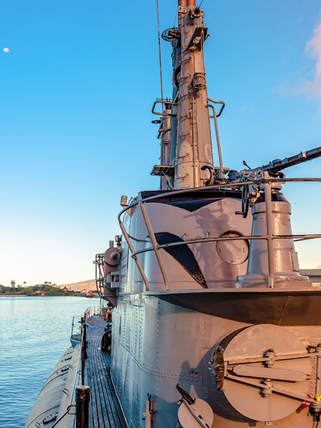USS Bowfin Submarine docked at Pearl Harbor with clear sky and water.