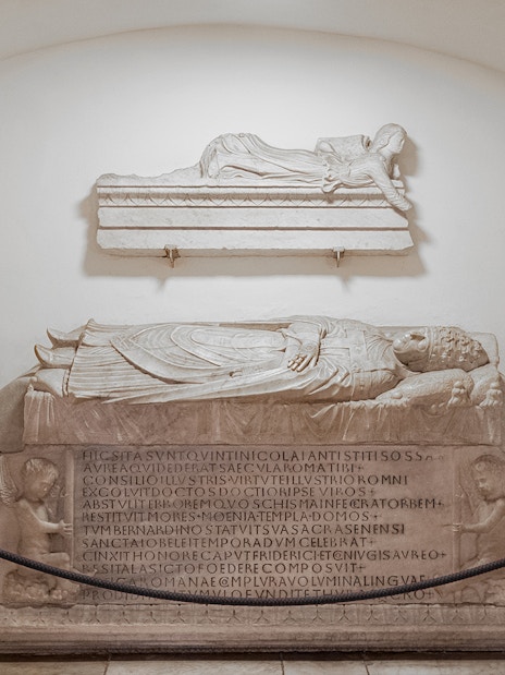 Tomb sculptures in Vatican Grottoes, depicting Papal Tomb with Latin inscriptions.