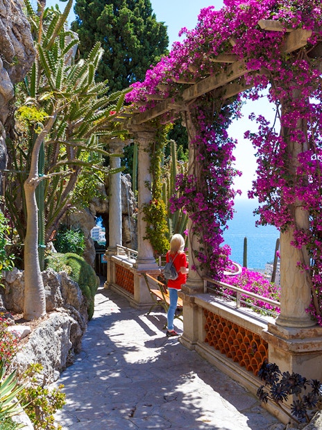 Pathway through Jardin Exotique in Eze with sea view and vibrant flowers.
