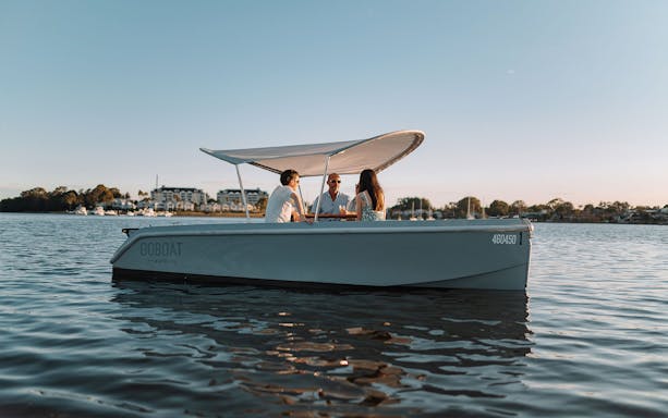 Self-drive electric picnic boat with passengers on Sydney harbor.
