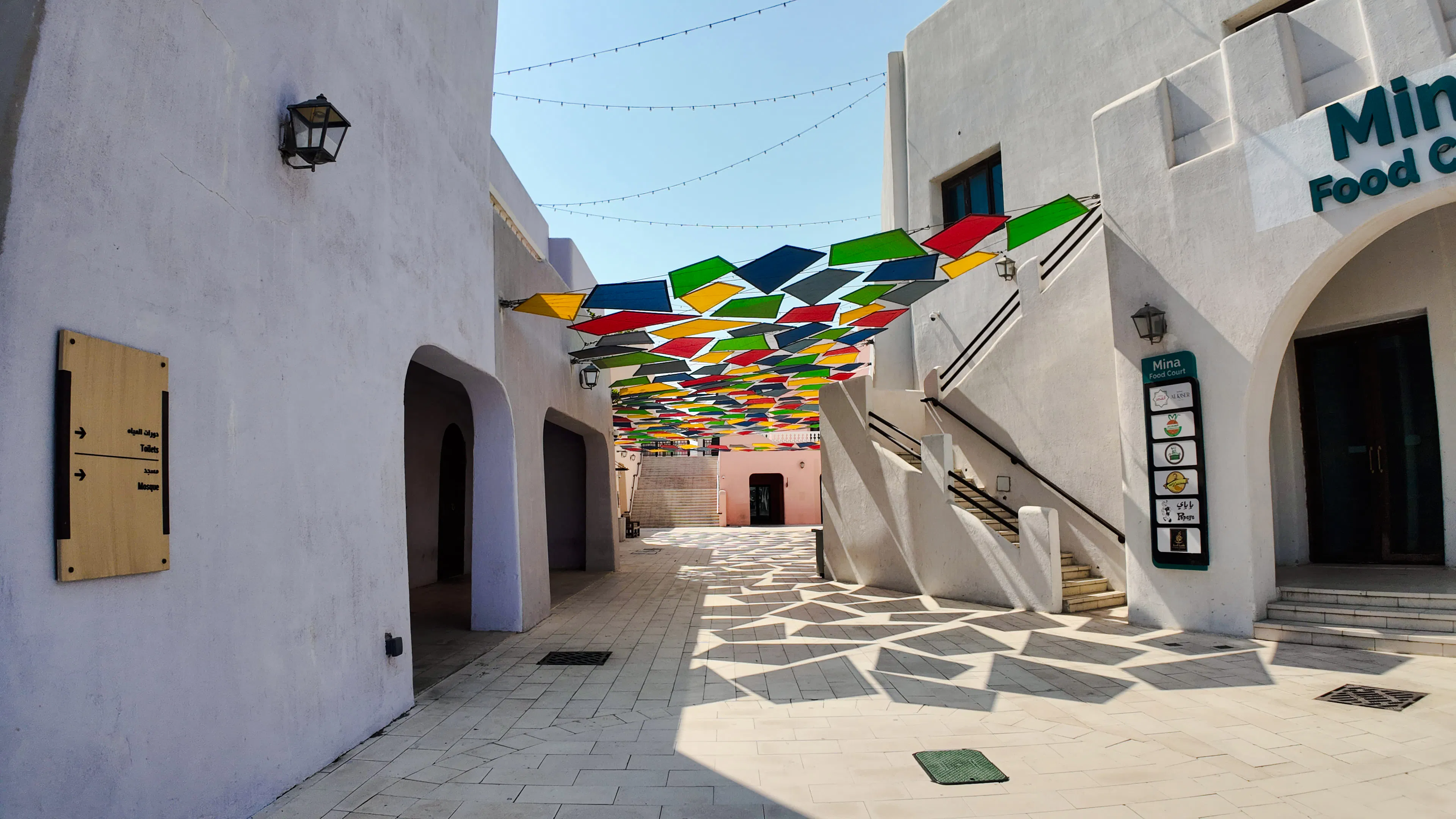 Colorful geometric canopy over a walkway in Doha's cultural district.