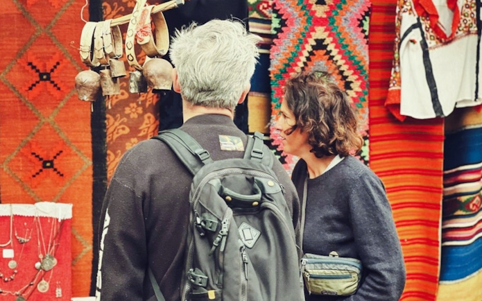 Guests browsing traditional textiles and crafts at Gjirokaster Old Bazaar.