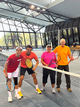 Tennis players posing on an indoor court at Melbourne Park.