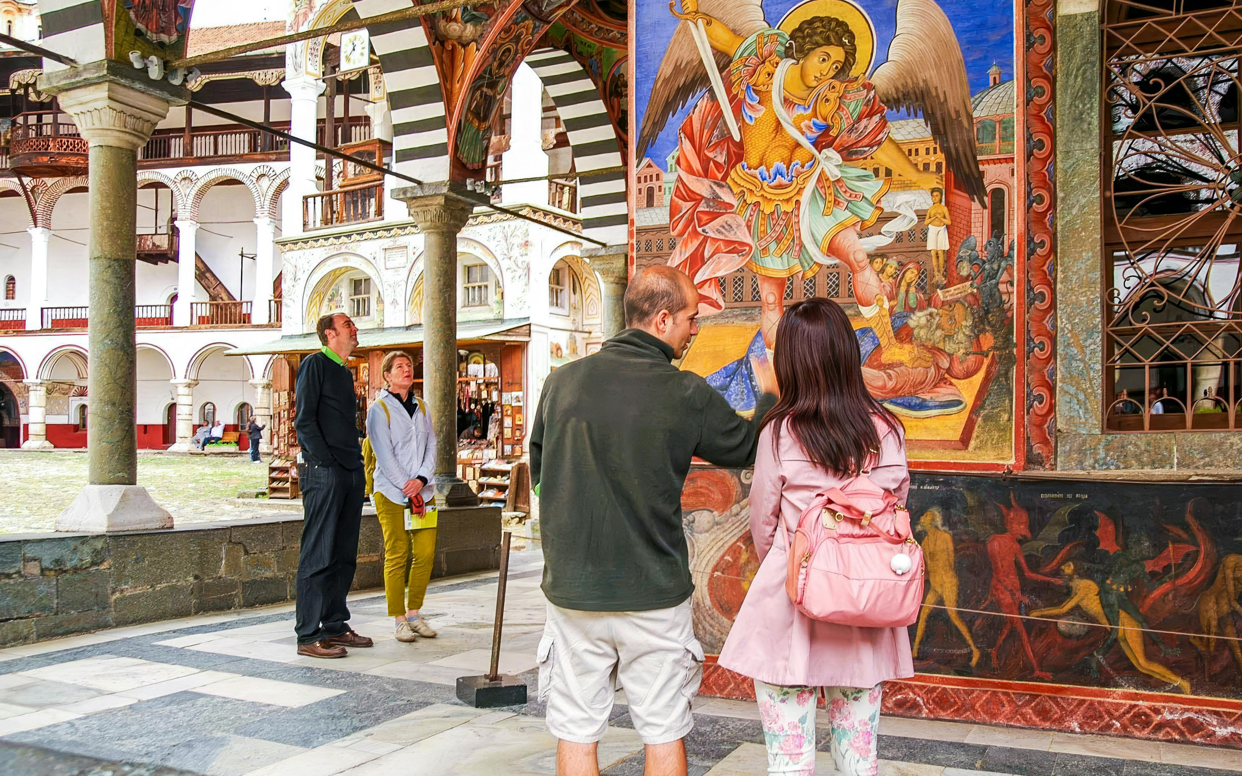 Visitors admire frescoes at Rila Monastery, Bulgaria.
