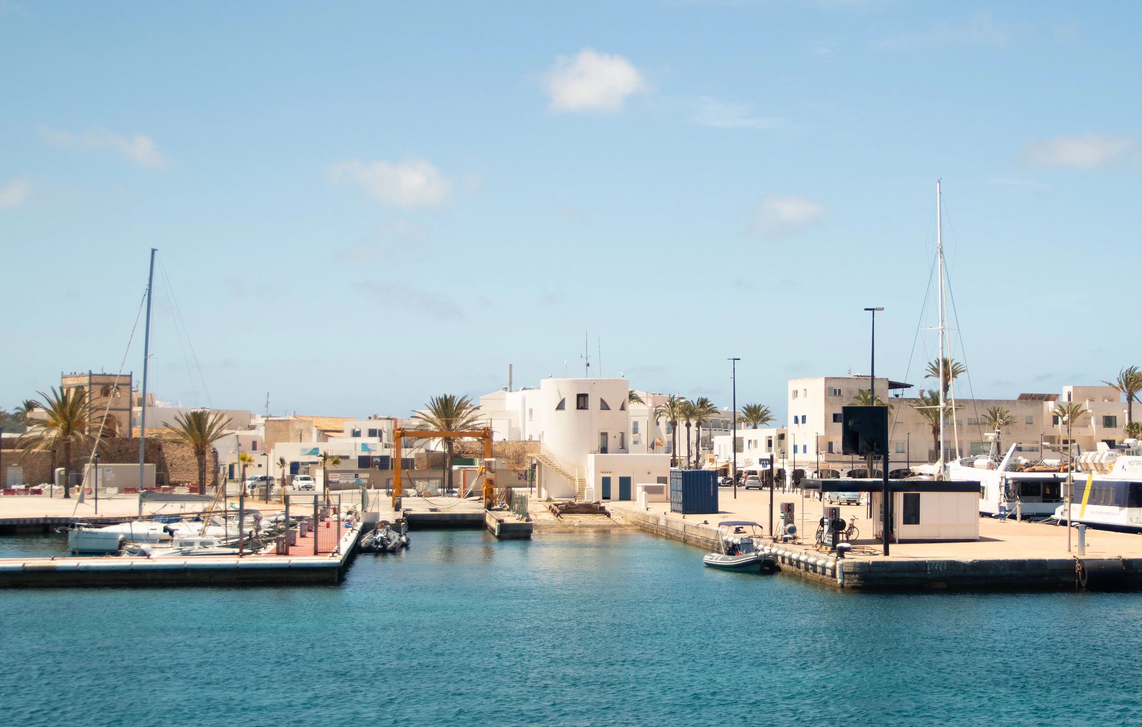 Formentera Port with boats docked and white buildings in the background.