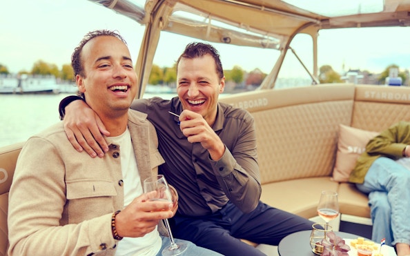 Guests enjoying a canal cruise in Amsterdam with champagne.