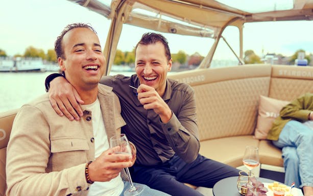 Guests enjoying a canal cruise in Amsterdam with champagne.