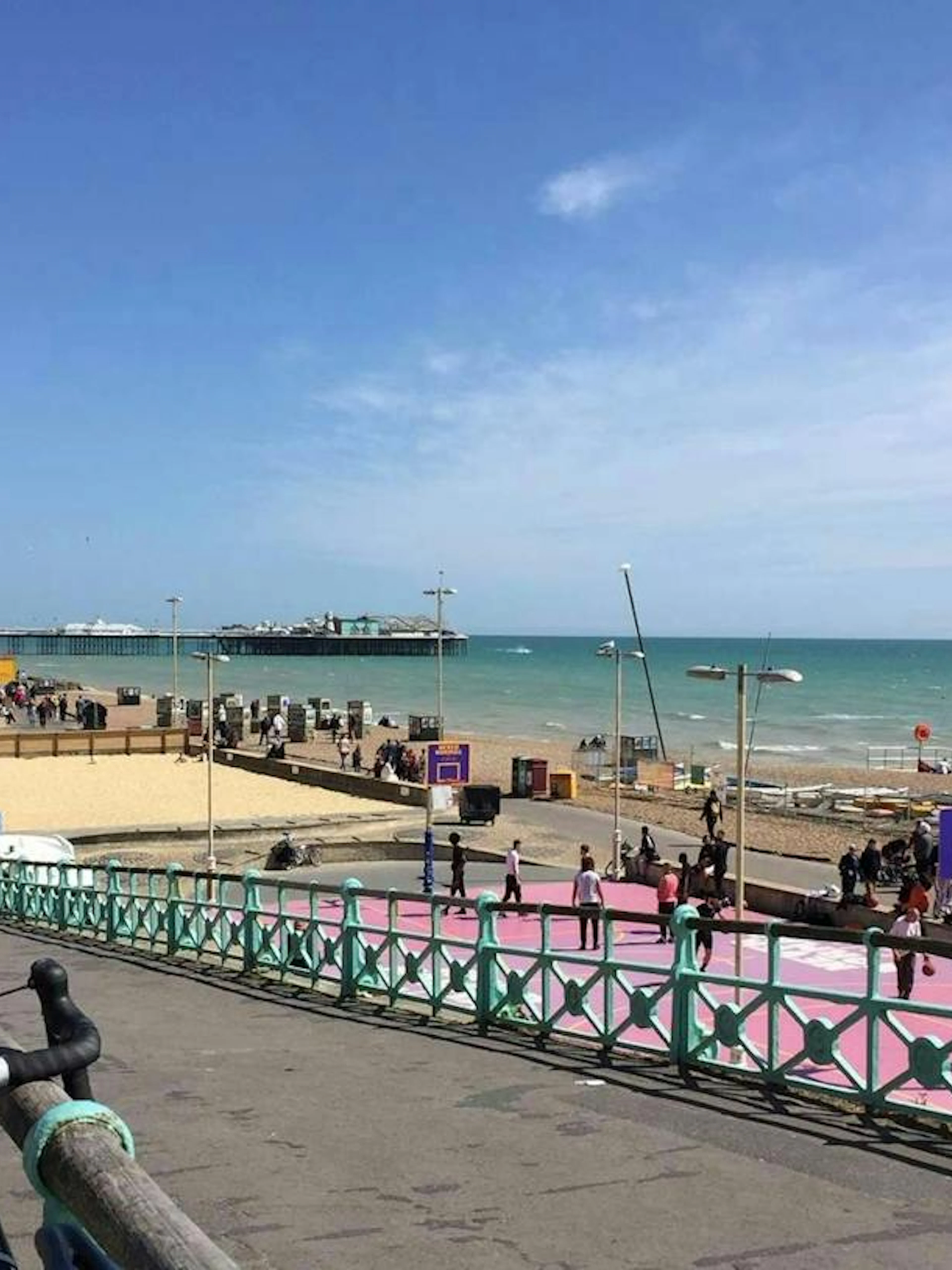 Brighton seafront view with promenade, beach, and pier in the background.