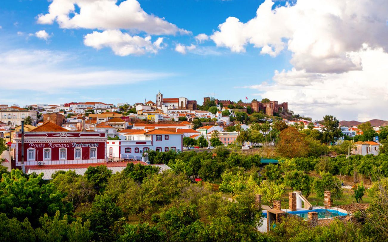 Silves town view with red castle and Ponte Romana Restaurant, Algarve, Portugal.