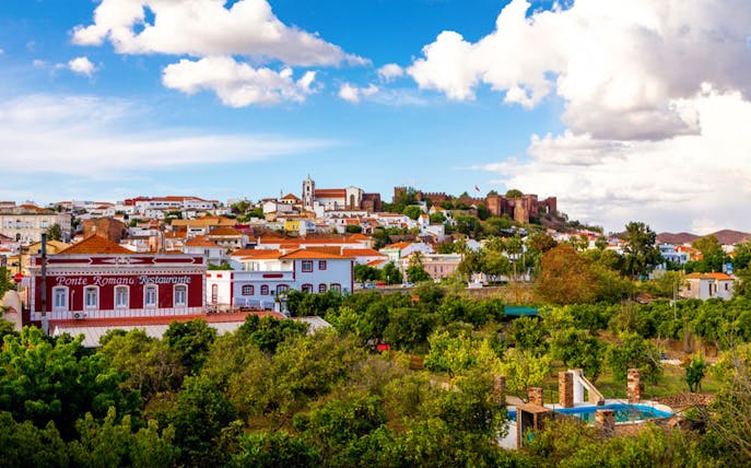 Silves town view with red castle and Ponte Romana Restaurant, Algarve, Portugal.