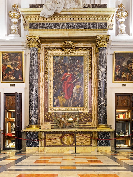 Interior of the Cathedral of Toledo featuring ornate paintings and marble columns.