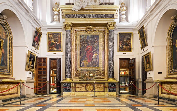 Interior of the Cathedral of Toledo featuring ornate paintings and marble columns.