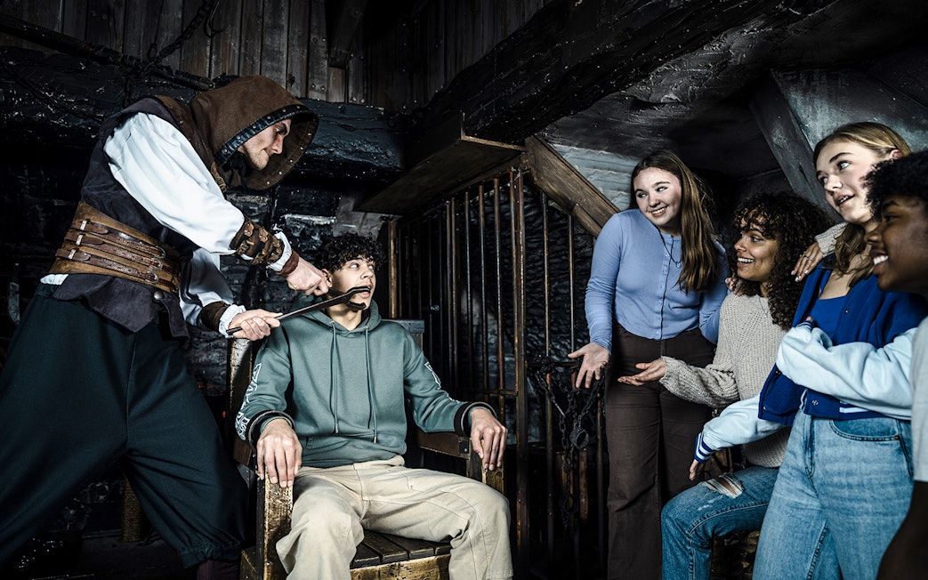 Guests experiencing a theatrical scene at the Amsterdam Dungeon.