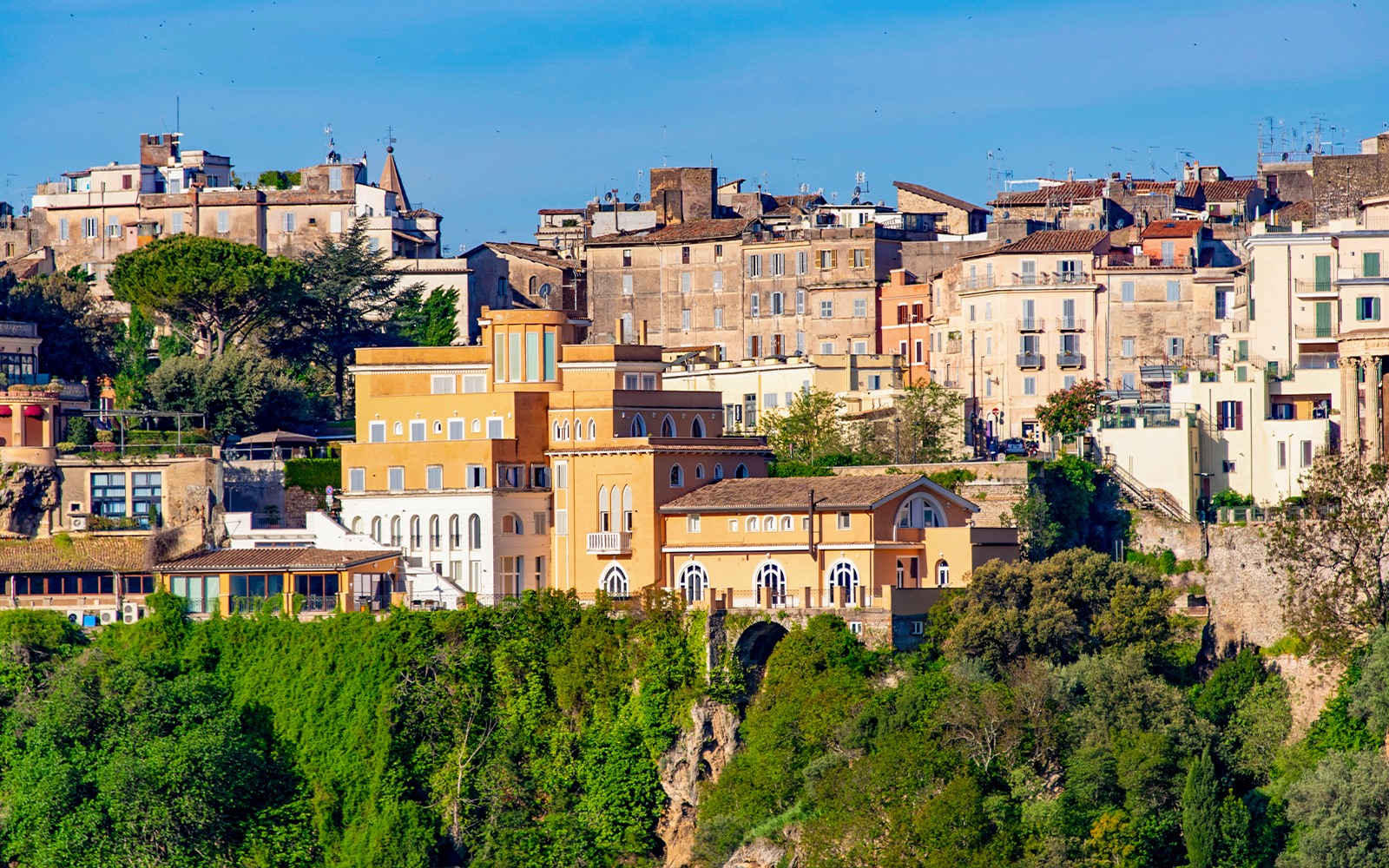 Tivoli townscape with historic buildings and lush gardens, Italy.