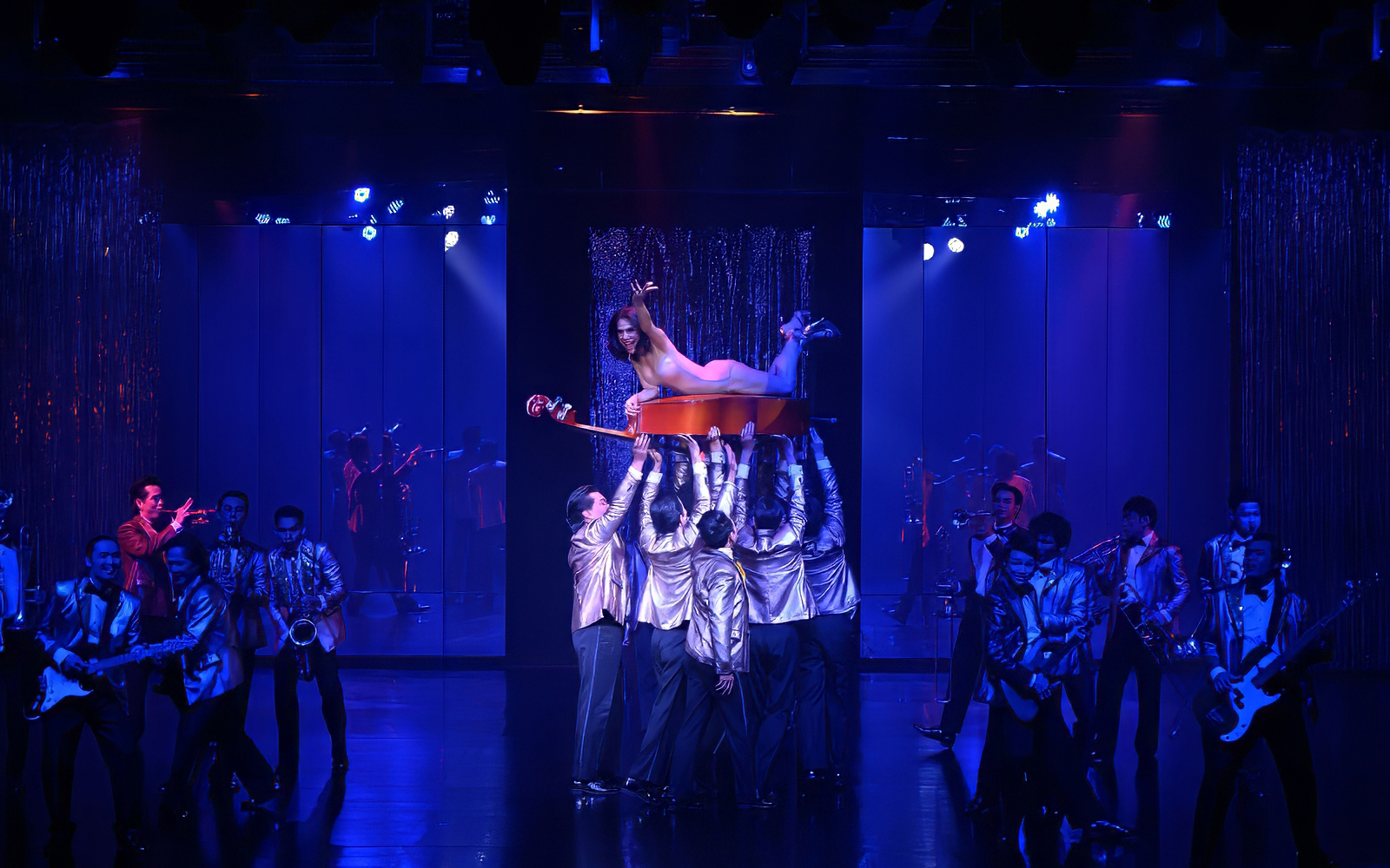 Calypso Cabaret performers in vibrant costumes during a live show, Bangkok.