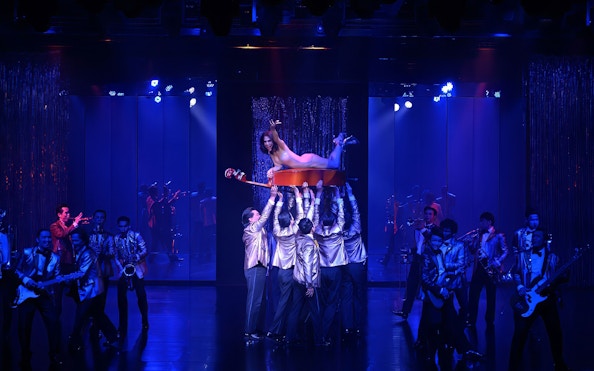 Calypso Cabaret performers in vibrant costumes during a live show, Bangkok.