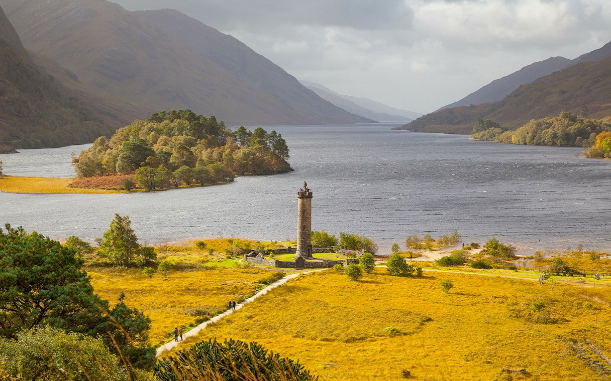 Glenfinnan Monument overlooking Loch Shiel with surrounding hills in Scotland.