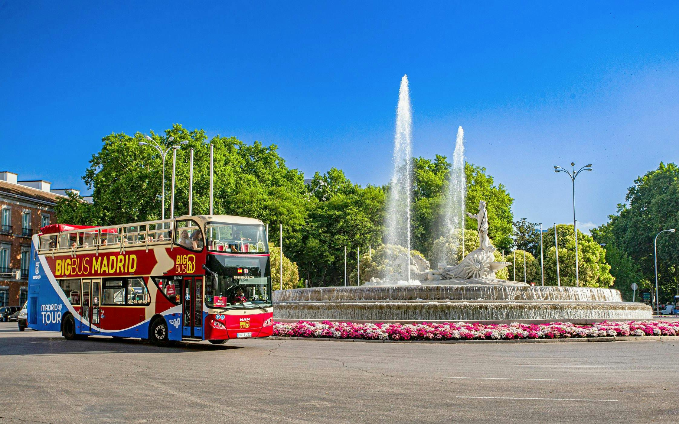 Big Bus Madrid driving past the Fountain of Neptune in Madrid.