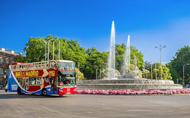 Big Bus Madrid driving past the Fountain of Neptune in Madrid.