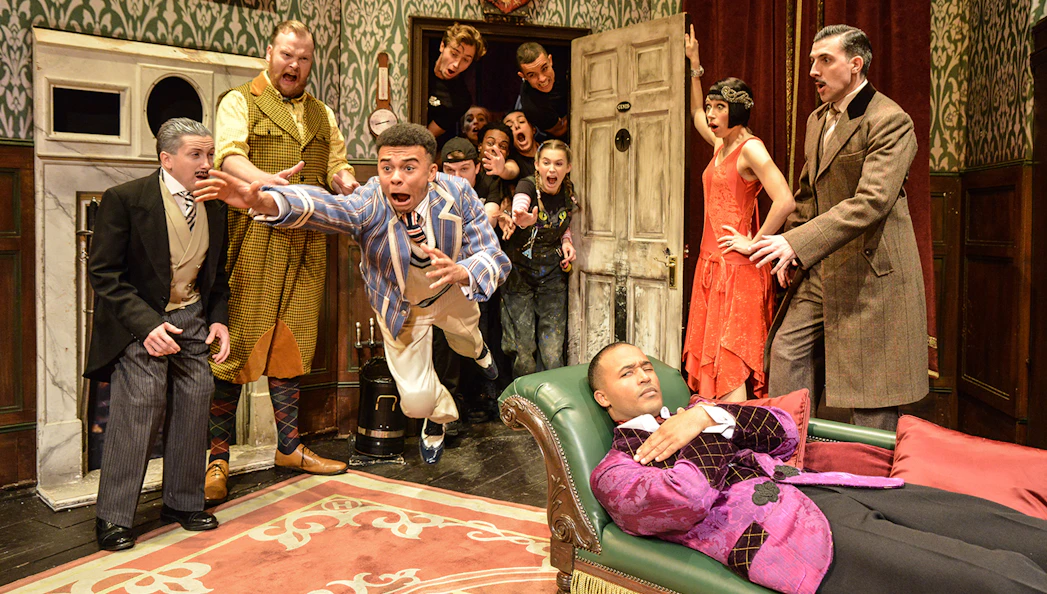 Actors performing a chaotic scene in "The Play That Goes Wrong" on stage.