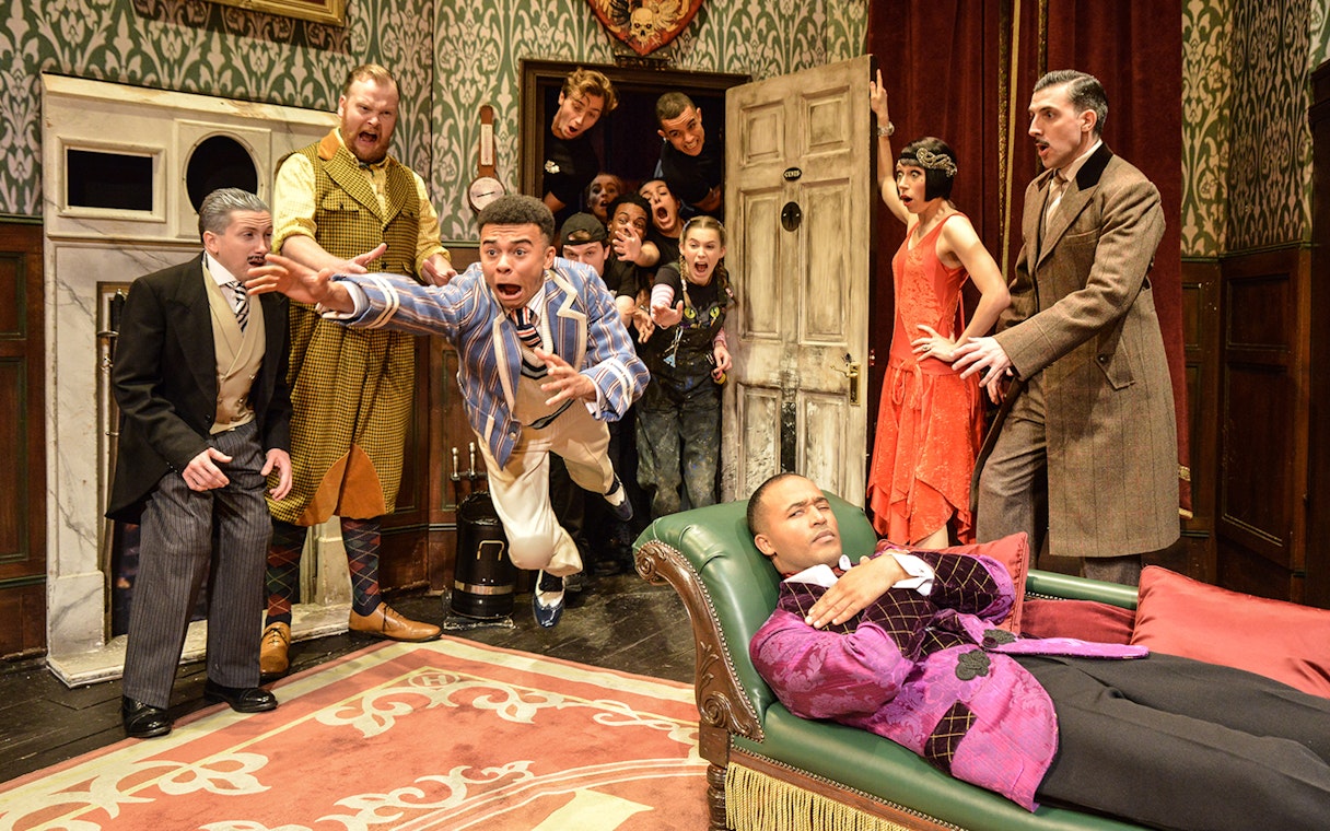 Actors performing a chaotic scene in "The Play That Goes Wrong" on stage.