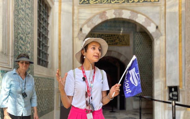Guide explaining Topkapi Palace history to tourists in Istanbul.